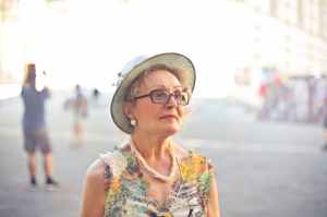 depth of field photography of woman in pastel color sleeveless shirt and white sunhat